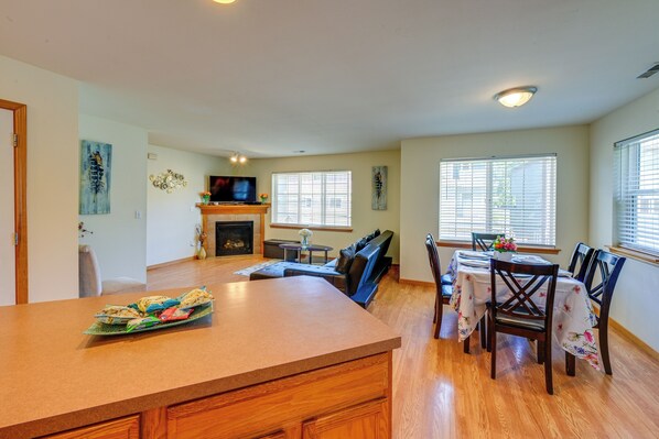 A spacious living area with a fireplace, seating, and a dining table set for six.