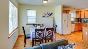 A dining area with a table set for four, wooden chairs, a vase with flowers, and a painting on the wall. - Great for Families! Spacious Retreat in Lynnwood (Lynnwood)