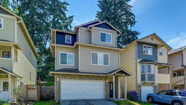 A two-story residential building with a garage, a driveway, and a car parked in the driveway. - Great for Families! Spacious Retreat in Lynnwood (Lynnwood)
