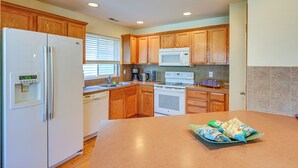 A kitchen with wooden cabinets, a refrigerator, a microwave, an oven, and a coffee maker. - Great for Families! Spacious Retreat in Lynnwood (Lynnwood)