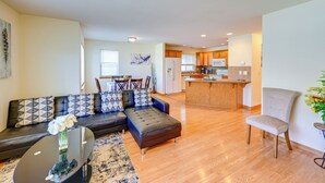 A modern living room with a sofa, a dining table, and a kitchen in the background. - Great for Families! Spacious Retreat in Lynnwood (Lynnwood)