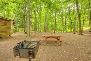A campsite with a picnic table and a grill.