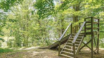 A wooden staircase leading up to a platform in a wooded area.