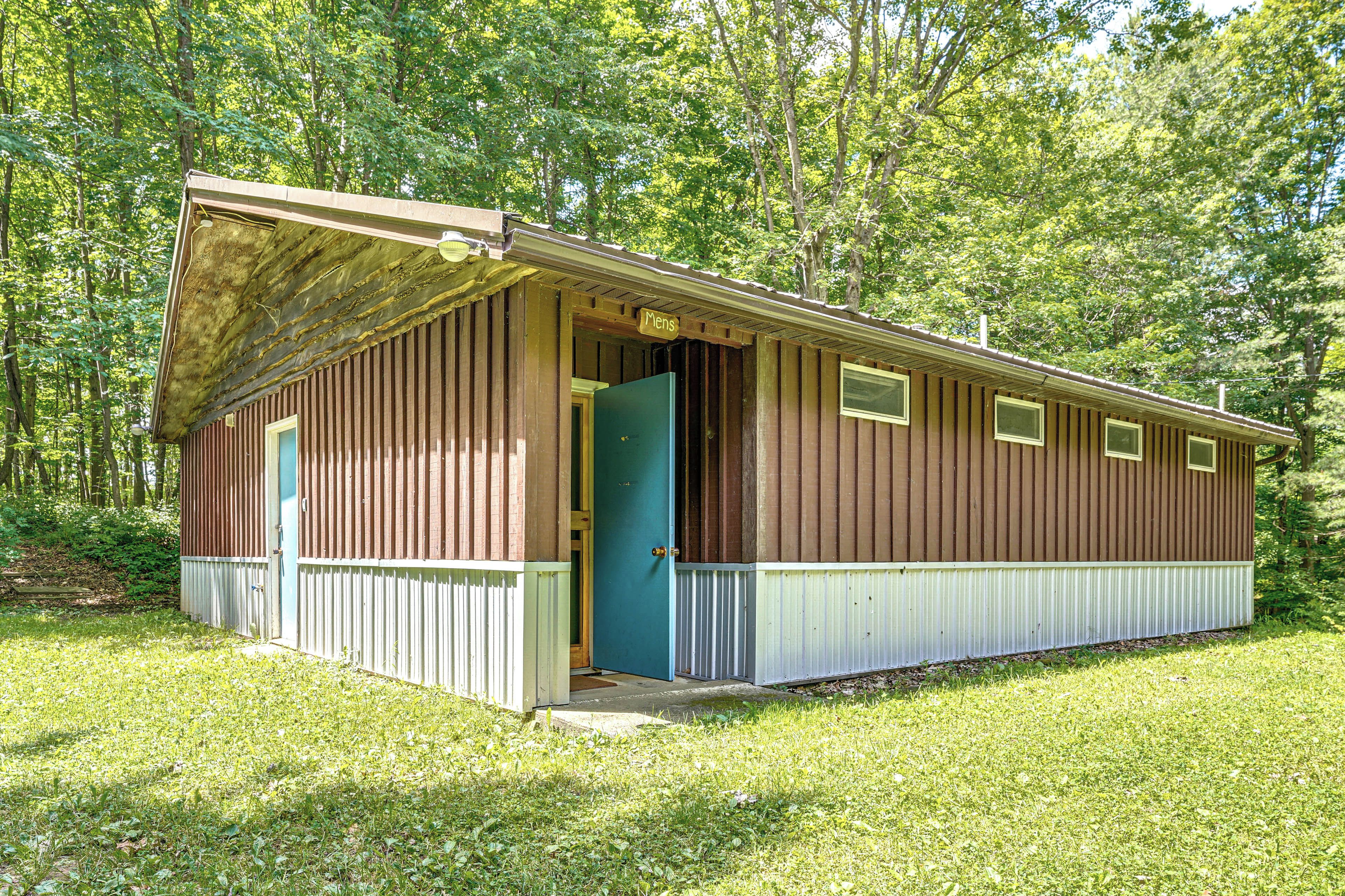 A single-story wooden cabin with a sloped roof, a front door, and a small porch area.