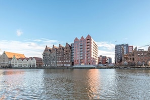 Paisatge urbà amb edificis històrics i un gratacels modern al costat del mar.
