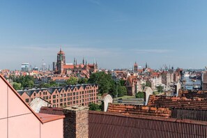A cityscape with historical architecture, including a prominent clock tower and spires, viewed from a high vantage point. - Nº 65A | Private Jacuzzi | AC | Pool, SPA & Gym (Gdańsk)