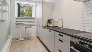 Eine moderne Küche mit Einbauofen, Spüle und Fenster mit Blick auf eine Grünfläche.