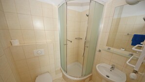 A bathroom with a glass-enclosed shower, a toilet, and a sink. - Zamkowy (Slupsk)
