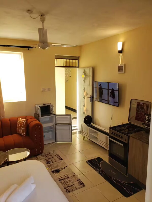 A compact living space with a kitchenette, a dining area, and a small seating area.