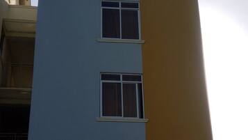 A multi-story building with a sign for 'Luckybee Apartments' on the side.