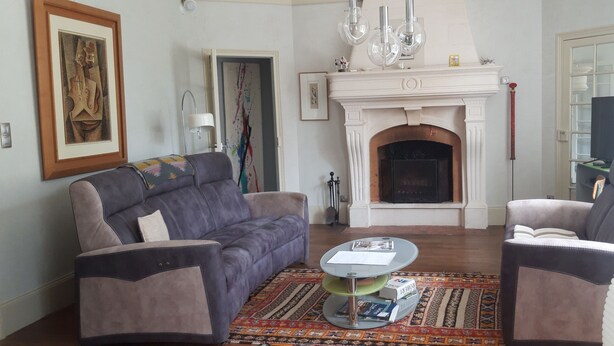 Ein Wohnzimmer mit Kamin, zwei Sofas, einem Couchtisch und einem Fernseher.