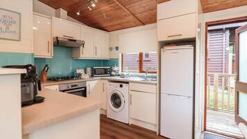 Cocina compacta con lavadora, microondas y refrigerador.