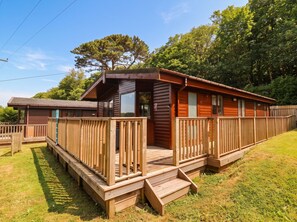 A wooden cabin with a deck, a small porch, and a number 31 sign. - Seagull Lodge (Ilfracombe)