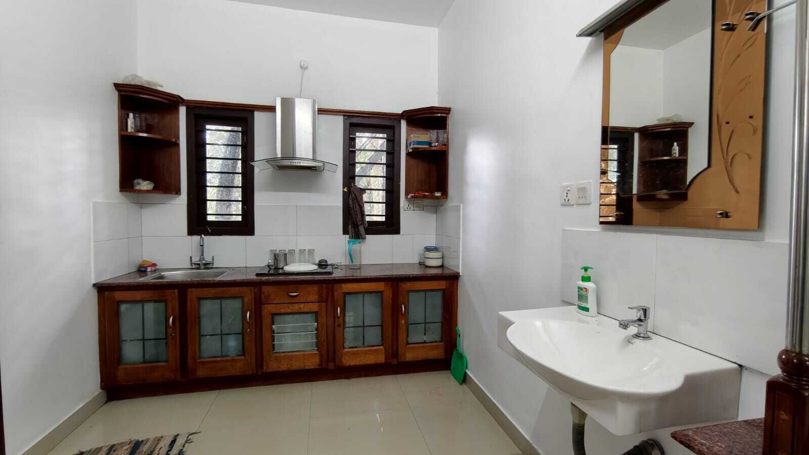 A kitchen with a built-in stove, a sink, and wooden cabinets with glass doors.