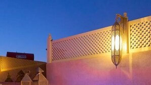 A hot tub with a wooden surround and a wall-mounted light fixture. - Luxury Private Riad Taj 2Min Jemaa Lefna (Marrakech)