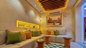 A cozy seating area with a sofa and armchairs, a patterned floor, and a wall-mounted picture. - Luxury Private Riad Taj 2Min Jemaa Lefna (Marrakech)