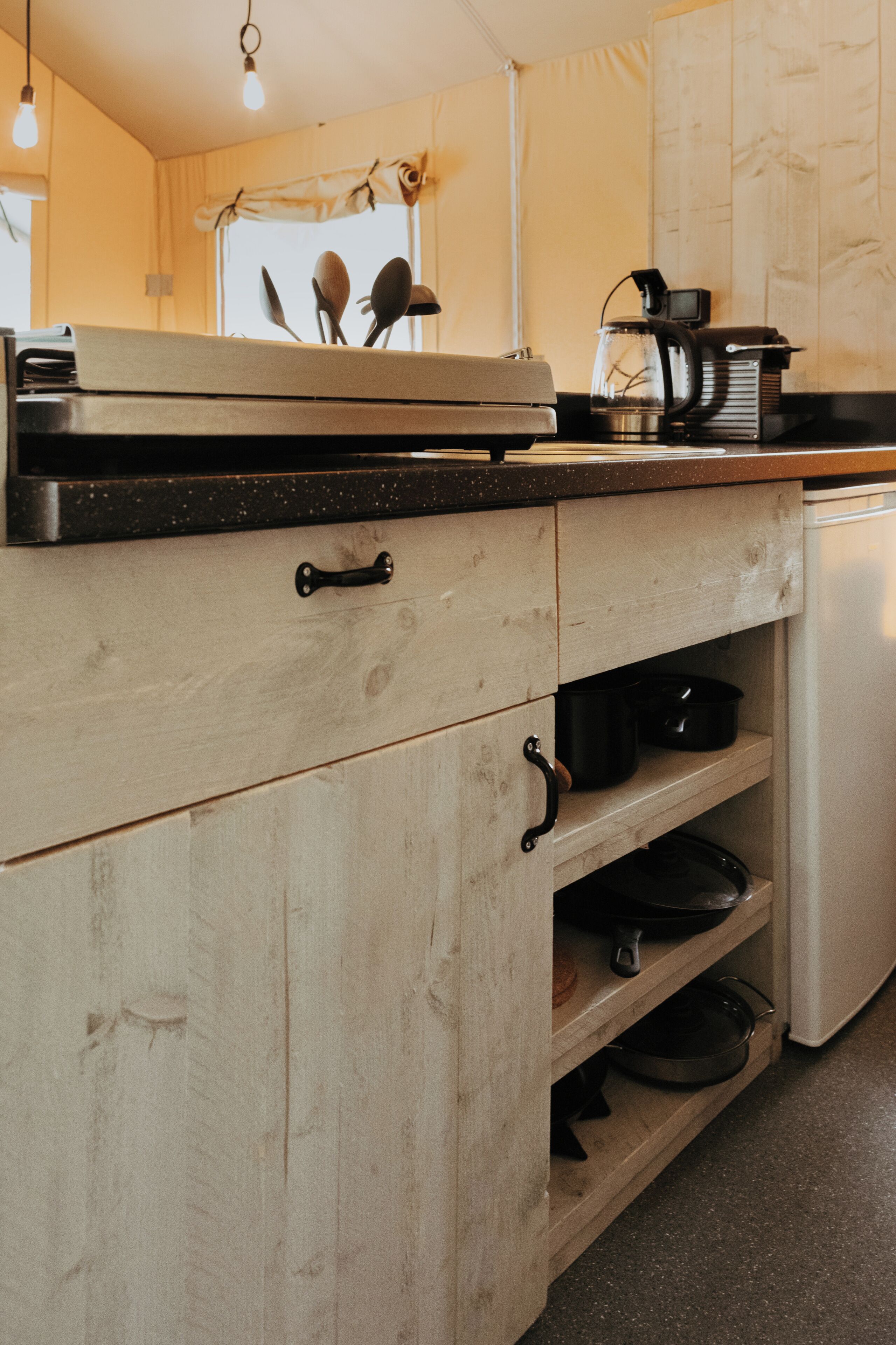 Una cocina con armarios de madera, una encimera y diversos electrodomésticos.