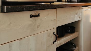 Una cocina con armarios de madera, una encimera y diversos electrodomésticos.