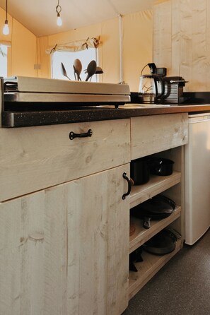 Una cocina con armarios de madera, una encimera y diversos electrodomésticos.