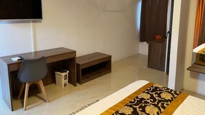 Une chambre d’hôtel équipée d’un bureau, d’une chaise, d’une télévision et d’un lit.