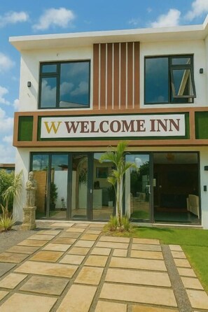Un edificio moderno con un letrero que dice 'WELCOME INN'.
