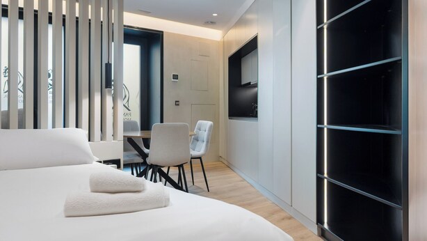 A modern hotel room with a bed, a desk, and a chair. - Panther Home Puerta Osario (Casco Antiguo)