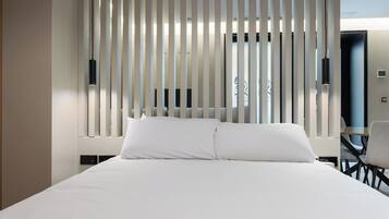 Una habitación de hotel con una cama grande, un escritorio y una silla.