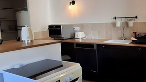 Una cucina moderna con forno integrato, microonde ed elettrodomestici inclusi.
