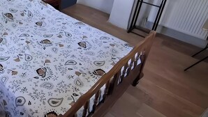 Una camera da letto con un letto, una scrivania, una sedia, un termosifone e una porta.