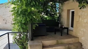 Un molo in legno con un muro di pietra, una ringhiera in metallo e un tavolino.