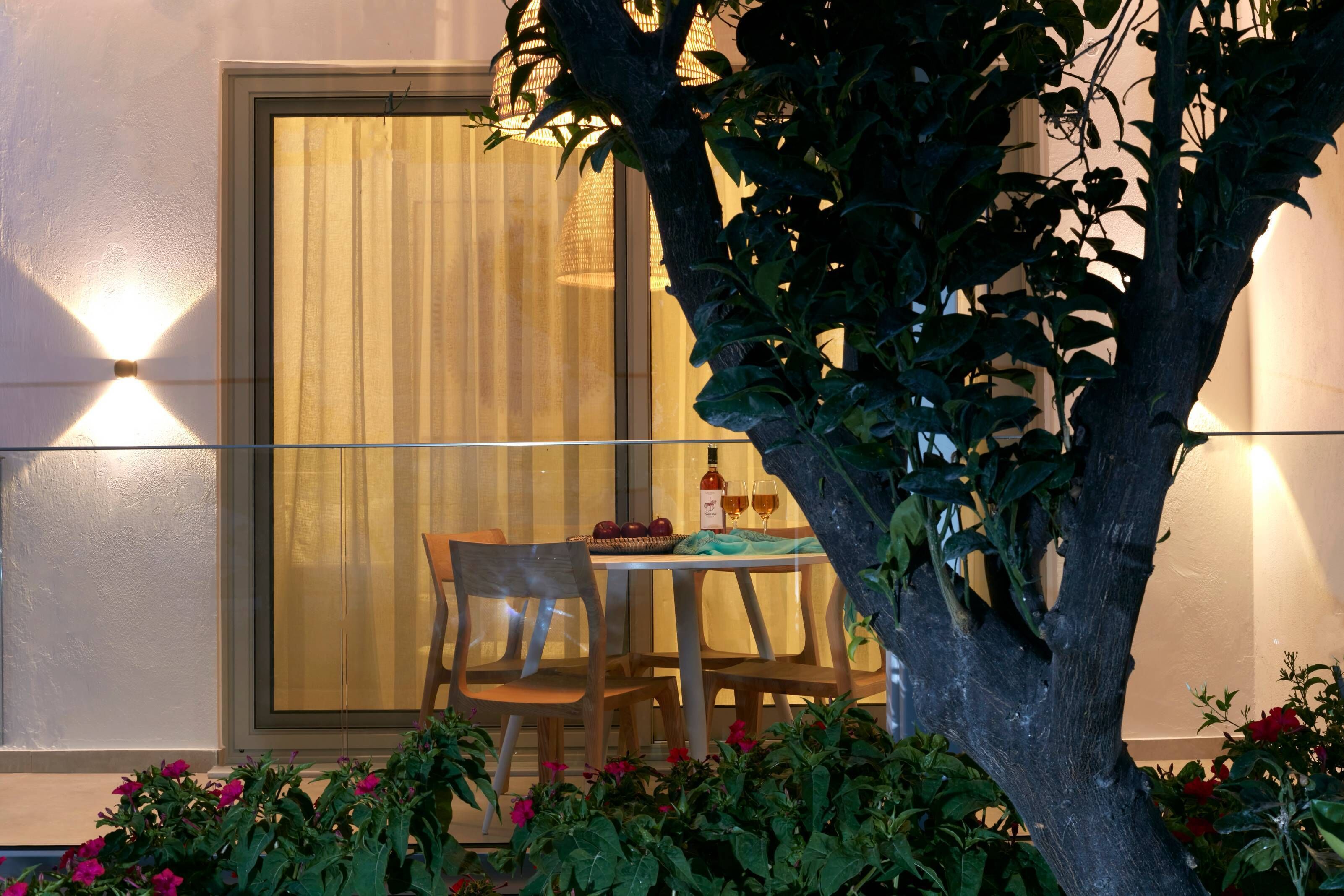 A dining area with a table set for two, a chair, and a bottle of wine.