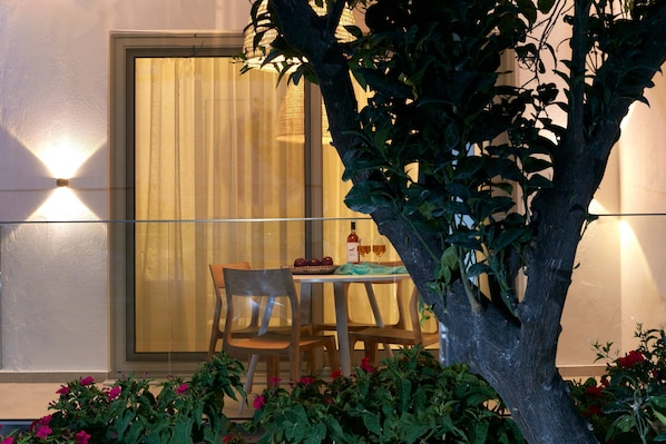 A dining area with a table set for two, a chair, and a bottle of wine.