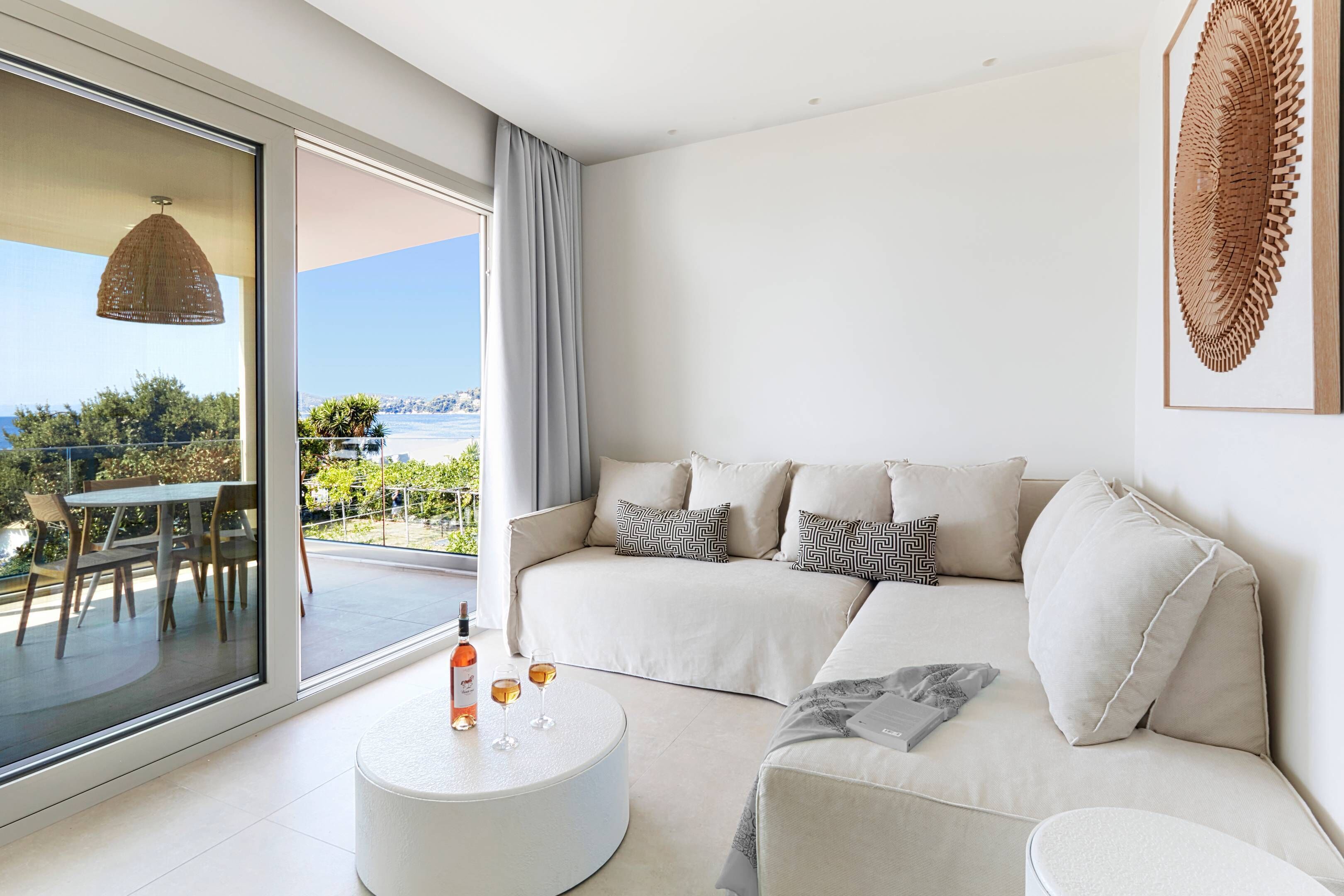 Una sala moderna con un sofá, una mesita redonda y vistas al exterior.