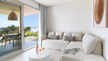 Una sala moderna con un sofá, una mesita redonda y vistas al exterior.