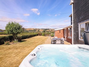 Un bain à remous dans un jardin, avec vue sur des collines ondoyantes.