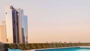 Ein Schwimmbecken mit Liegestühlen und ein modernes Gebäude im Hintergrund.