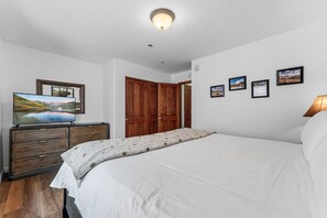 A bedroom with a bed, a dresser, a television, and a door. - Frisco Mountain Condo | Fireplace, Garage and Great Location (Frisco)