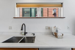 A kitchen with a stainless steel sink, a window with blinds, and a small shelf above the window. - Frisco Mountain Condo | Fireplace, Garage and Great Location (Frisco)
