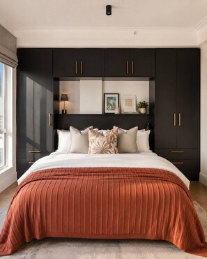 A bedroom with a large bed, dark cabinets, a bedside table, and a window. - Balcony Suite The Valour in De Waterkant (Cape Town)