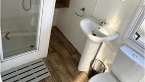 Une petite salle de bain comprenant une douche, un lavabo et des toilettes.