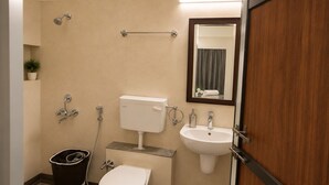 A bathroom with a toilet, bidet, sink, and a mirror. - Pinakii Comfort Stay Suites Prabhadevi (Mumbai)