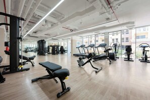 A gym with treadmills, weight machines, and a bench. - StayShort - Contemporary Studio Sleeps 2 in JVC (JVC)