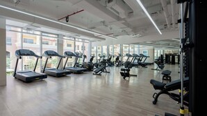 A gym with treadmills, weight machines, and exercise mats. - StayShort - Contemporary Studio Sleeps 2 in JVC (JVC)