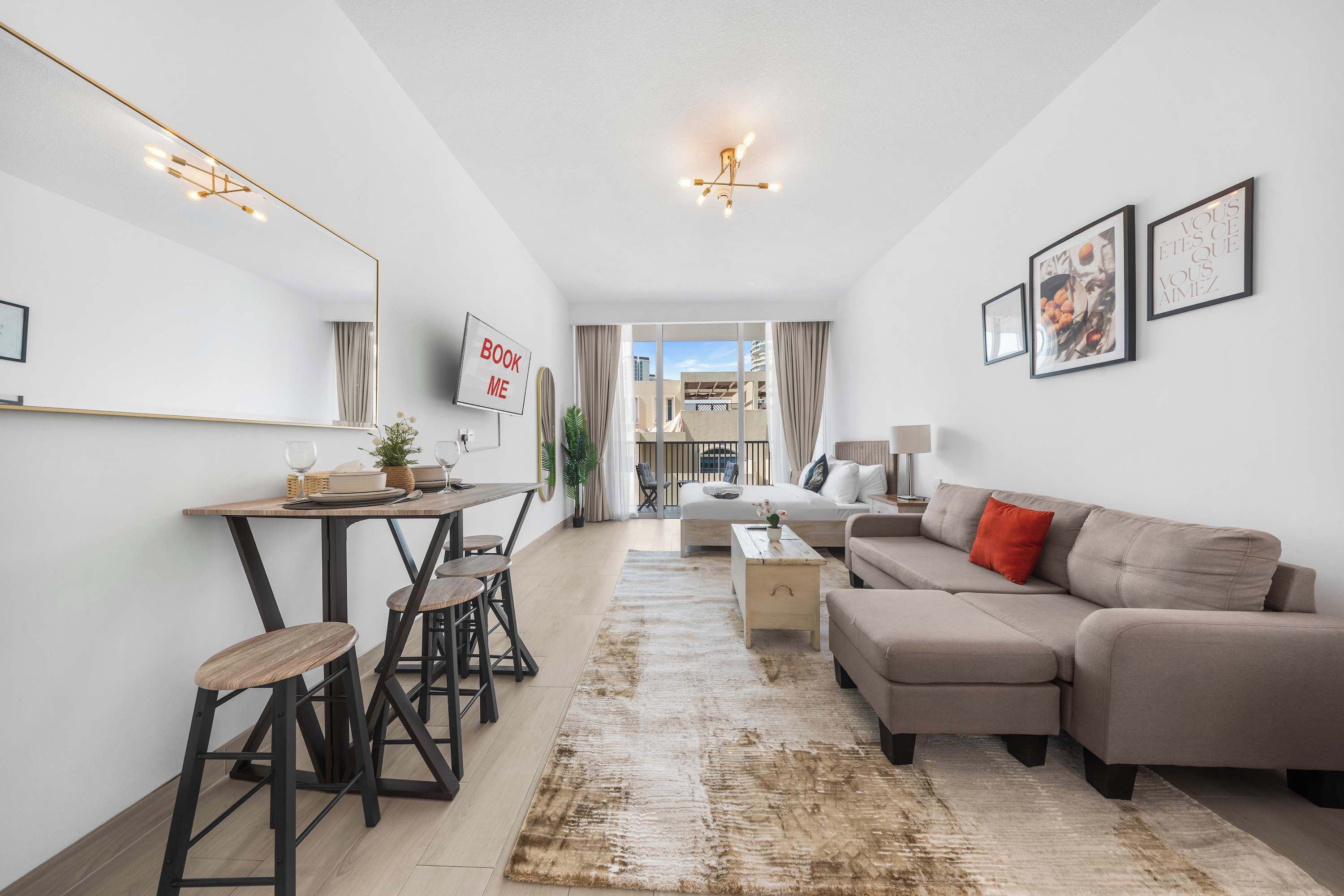 Ein modernes Wohnzimmer mit einer Couch, einem Esstisch mit Stühlen, einem Couchtisch und einem großen Spiegel an der Wand.