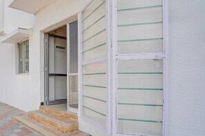 Fachada de un edificio con área de recepción, una puerta y un conjunto de escalones de madera que conducen a la entrada.