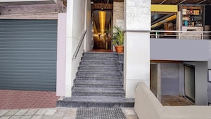 A staircase leading to a bar area with a potted plant on the landing. - Collection O Metro Park Opp Kalasipalya (Bangalore)