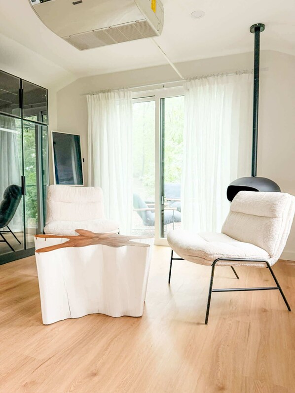 Ein modernes Wohnzimmer mit einem weißen Sofa, einem Couchtisch und einer Stehlampe.