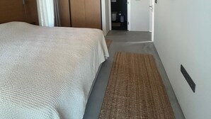 A bedroom with a large bed, a wooden ceiling, and a woven rug. - Elmalı Guest House 
A simple, serene, and deeply peaceful life awaits you! (Muğla)