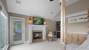 A room with a fireplace, a television mounted above it, and a bed with a canopy. - The Perch - Big Canoe, GA (Big Canoe)