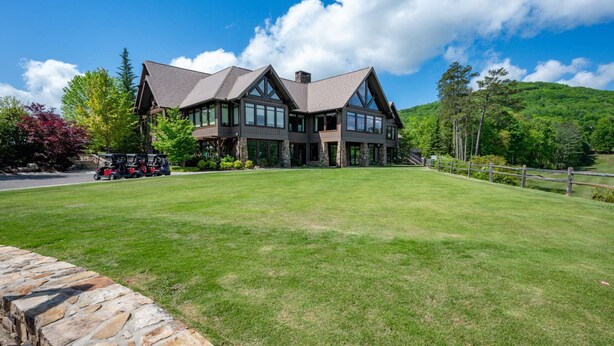 A large, modern two-story house with a spacious front lawn and a stone wall. - The Perch - Big Canoe, GA (Big Canoe)